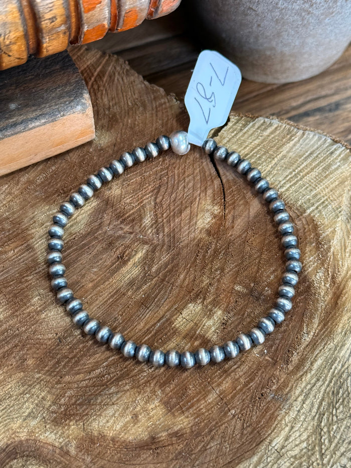 Sterling silver beaded stretchy bracelet with blue stamped tag at center