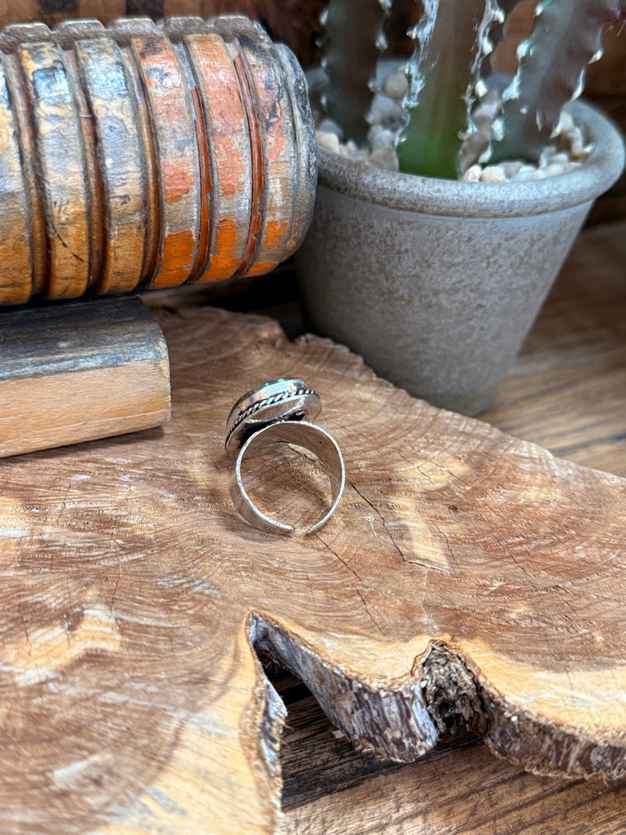 Adjustable silver ring with oval blue-green stone, open back and side band