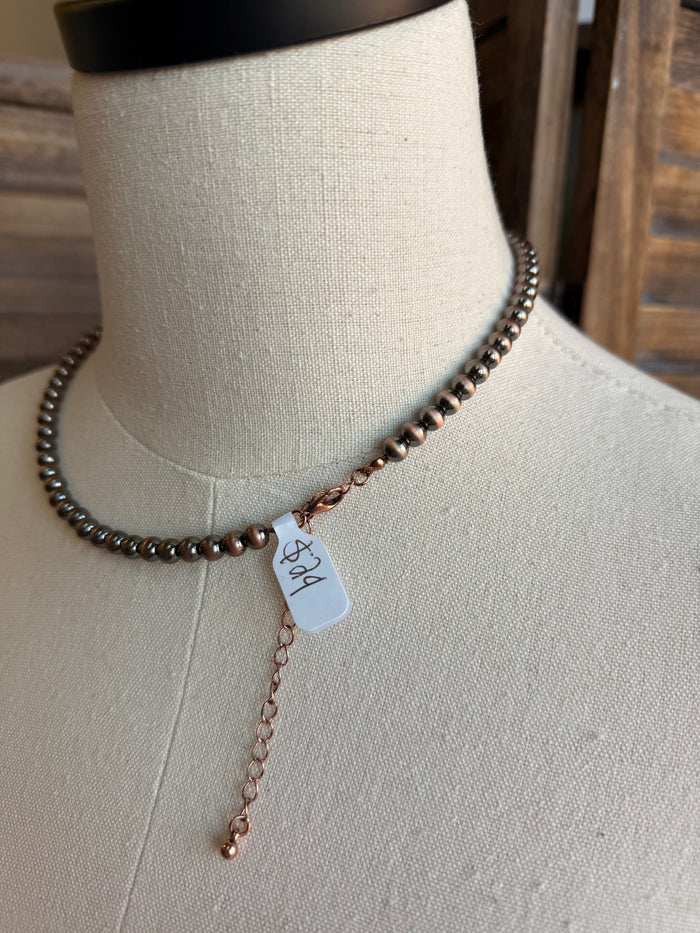 18-inch 6mm beaded necklace with silver-tone beads, copper-tone charm and tassel