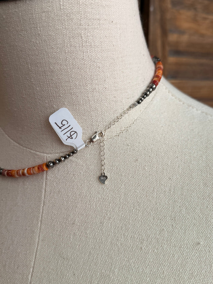 Orange heishi necklace clasp with small sterling charm and bead accents