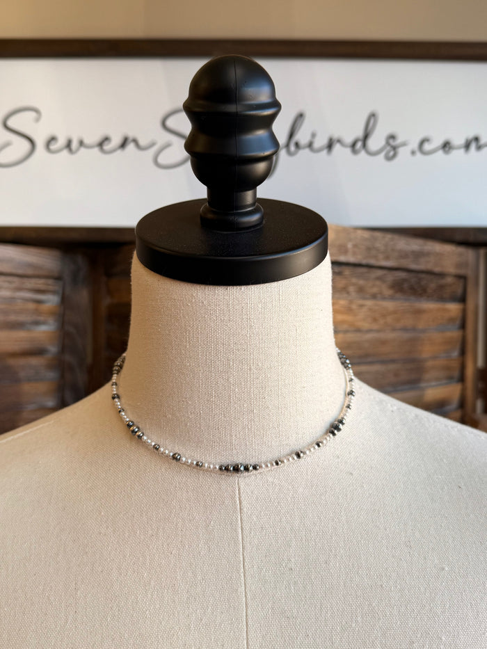 Freshwater pearl choker necklace worn on mannequin bust, layered silver and pearl beads