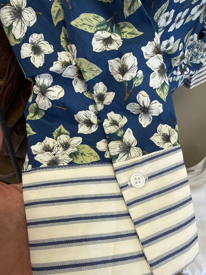 Floral cotton pullover with navy and green blooms, striped hem band, and button front