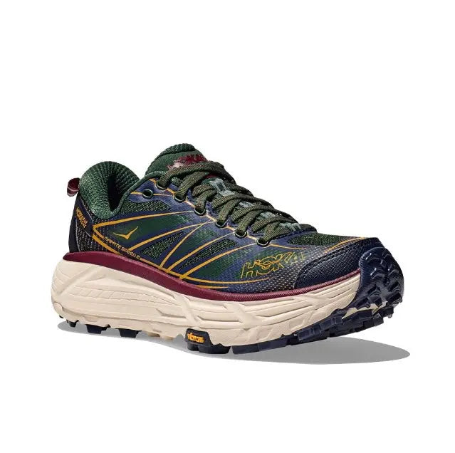 Trail running shoe in dark navy and green with cream midsole, maroon and blue outsole