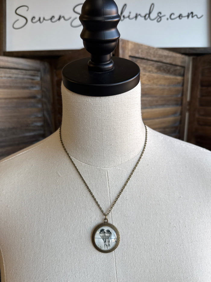 Round glass bird pendant necklace on silver-tone chain