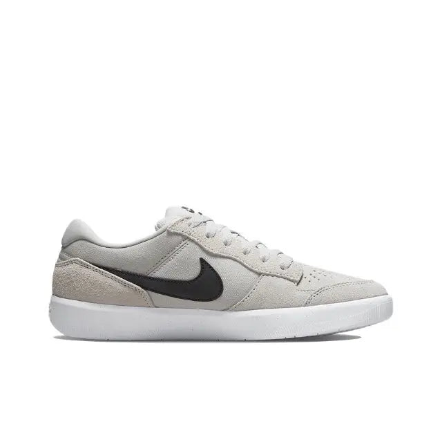 Light grey low-top skate shoe with black swoosh and white rubber sole