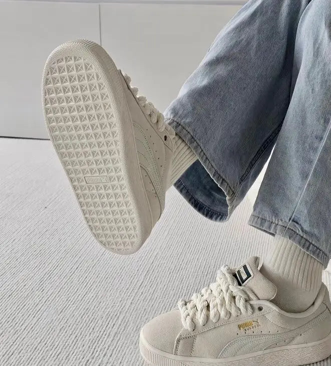 Puma suede sneaker with lace-up upper and textured outsole, worn with light jeans