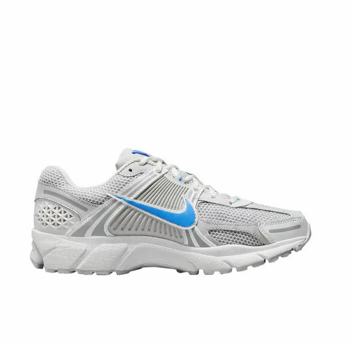 Running shoes 3/4 view: white mesh upper with blue swoosh and layered gray sole