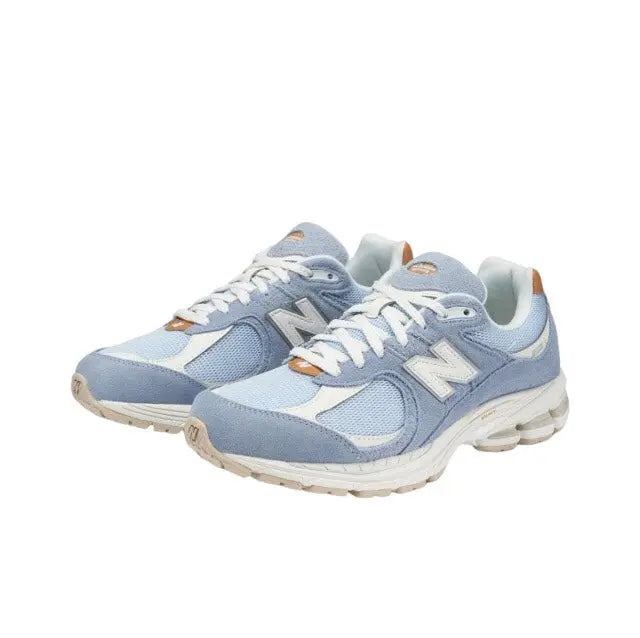 New Balance 2002R sneaker, side view, light blue mesh with white laces and tan accents