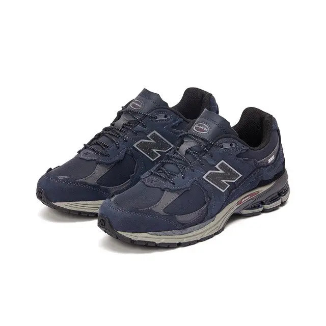 Navy New Balance 2002R sneakers with large N logo and layered upper panels