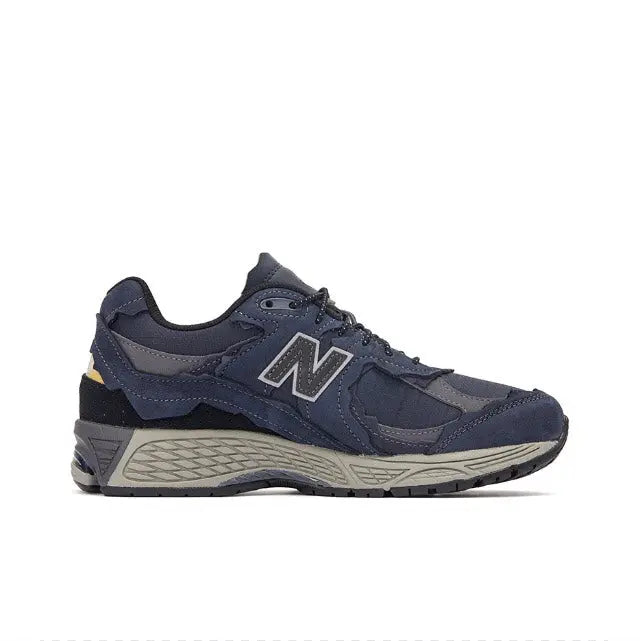 Side view of navy New Balance 2002R lace-up sneakers with gray midsole