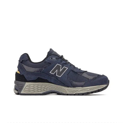 Side view of navy New Balance 2002R lace-up sneakers with gray midsole