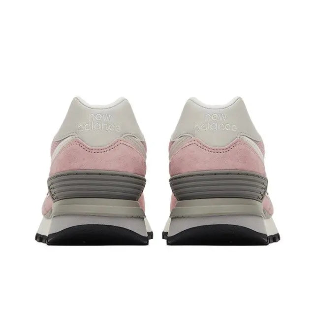 New Balance 574 pink sneaker pair with heel tabs, gray striped midsole, black outsole