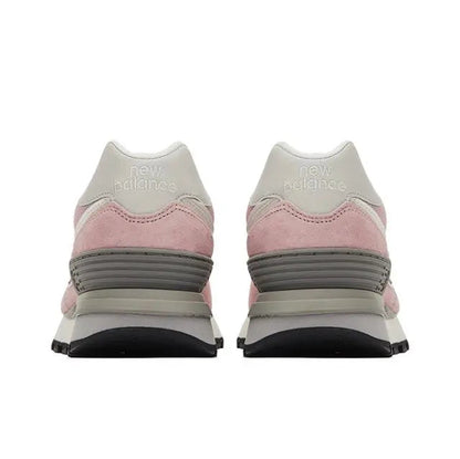 New Balance 574 pink sneaker pair with heel tabs, gray striped midsole, black outsole