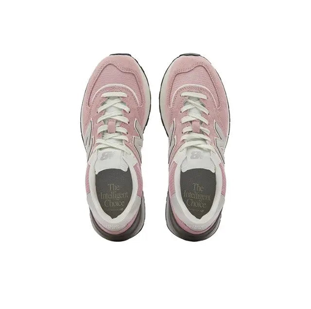 New Balance 574 pink lace-up sneakers with white laces, gray interior, black outsole