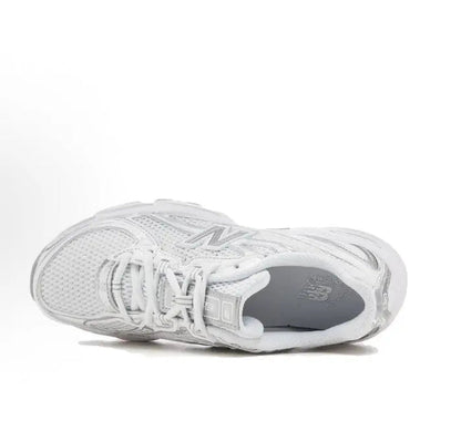White lace-up sneaker, side view with textured mesh upper and cushioned collar