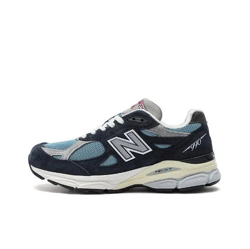 New Balance 990 sneakers in dark navy with light blue panels, white sole.