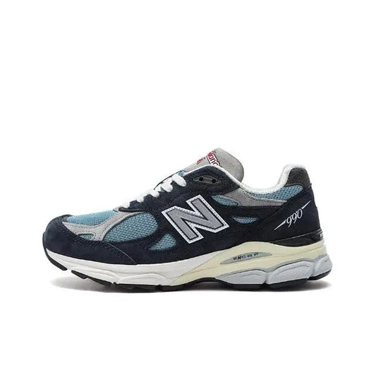 New Balance 990 sneakers in dark navy with light blue panels, white sole.
