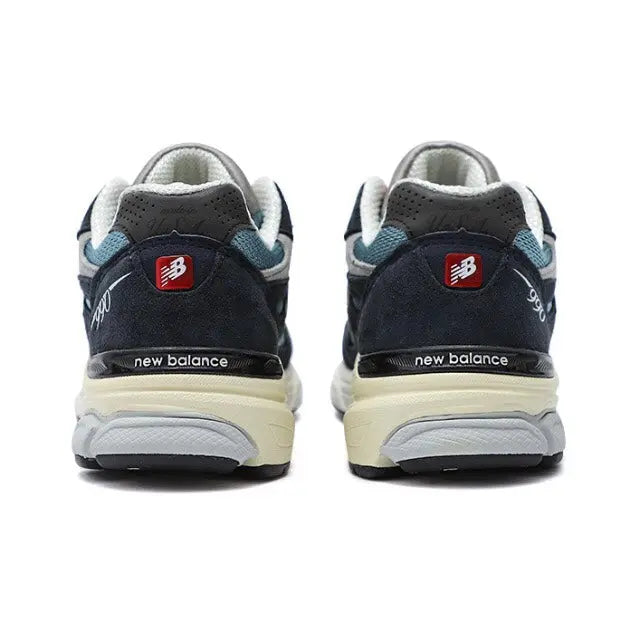 New Balance 990 sneakers, rear view with dark navy heel and light blue trim.