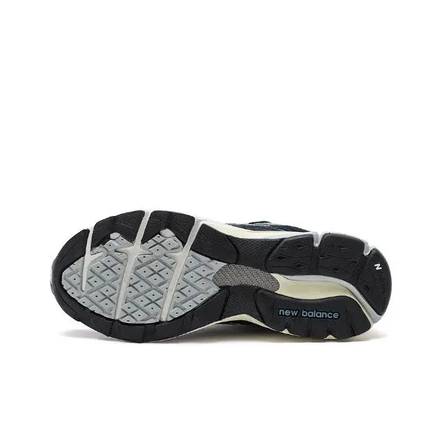 New Balance 990 sneakers outsole view, black and light gray traction pattern.