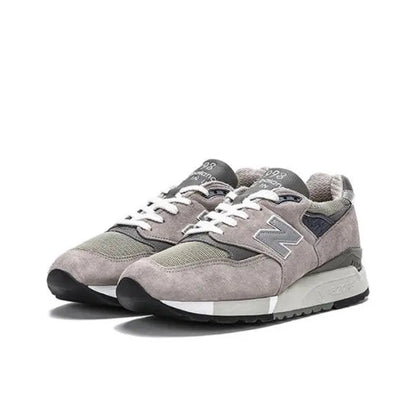 Grey low-top sneakers with N logo, lace-up front, cushioned midsole, rubber outsole