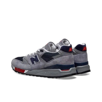 New Balance 998 grey sneakers with navy panels and red heel accents