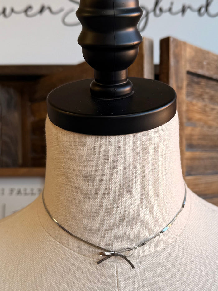 Silver bow chain choker with small bow pendant at center front