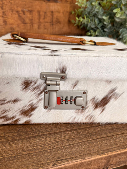 Hair-on cowhide jewelry box with tan leather strap and metal combination lock