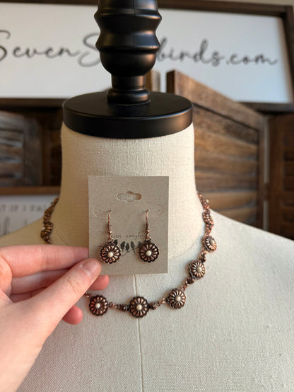 Copper-toned concho drop earrings with turquoise stone accents, on display card