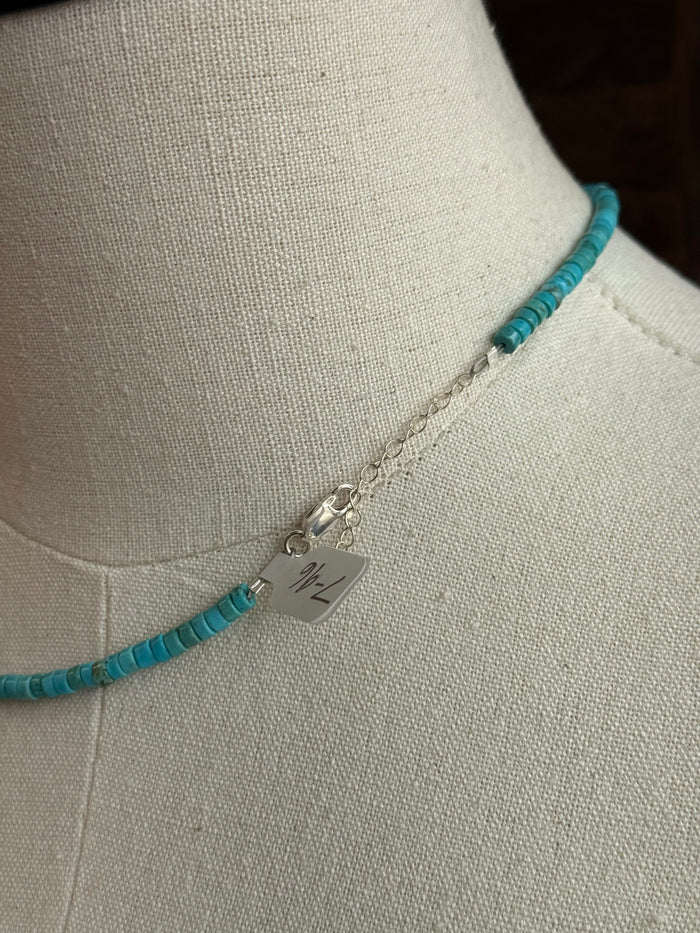 Sterling clasp charm on blue turquoise heishi bead necklace