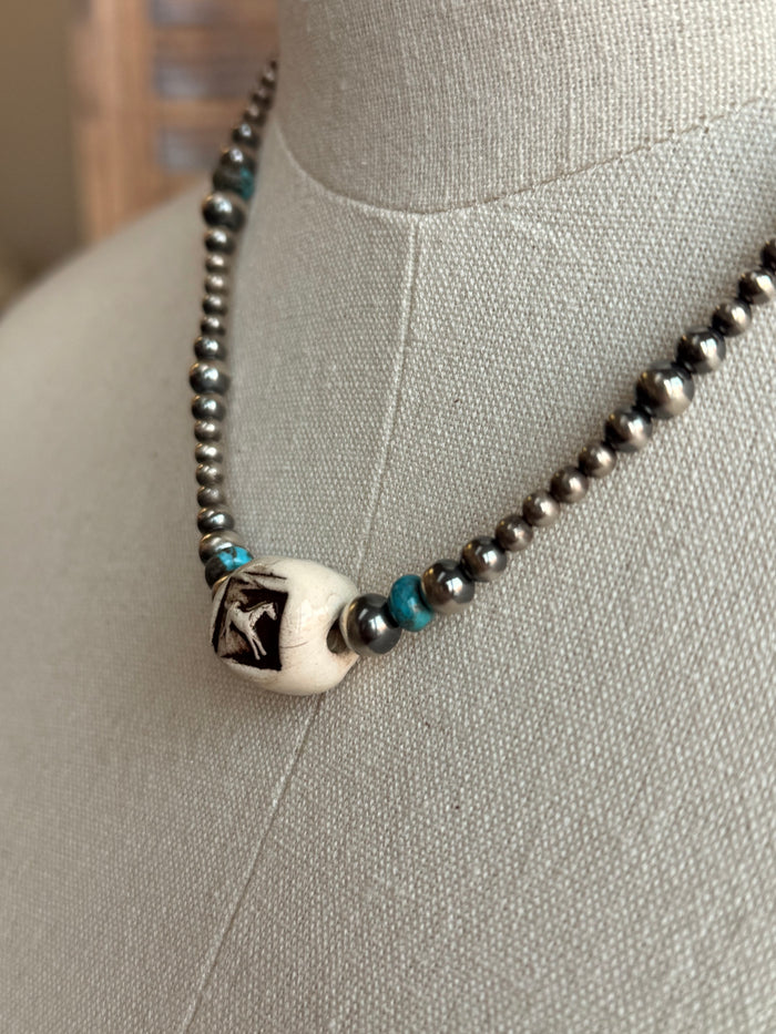 Running horse charm with turquoise bead accents on a silver bead necklace