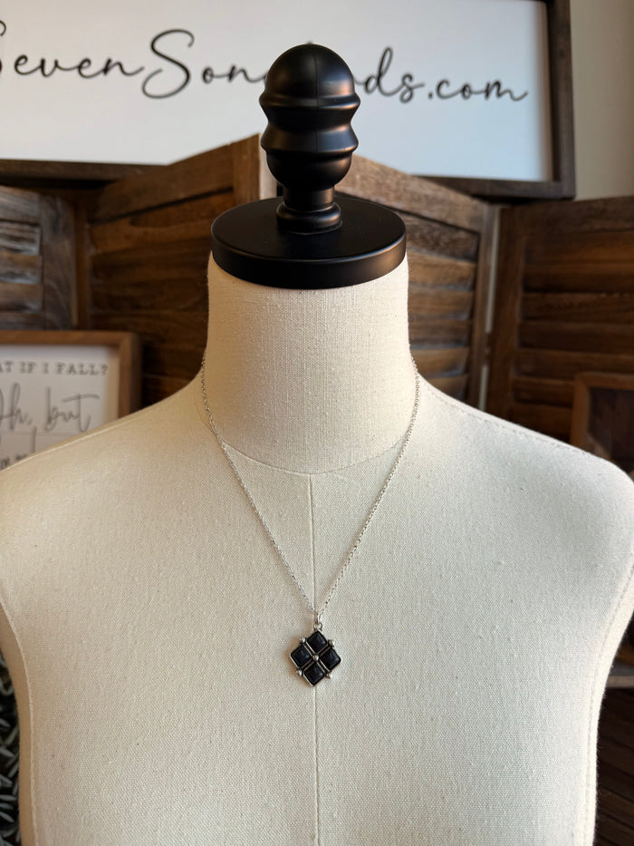Diamond four-stone necklace with a black square pendant on a silver chain