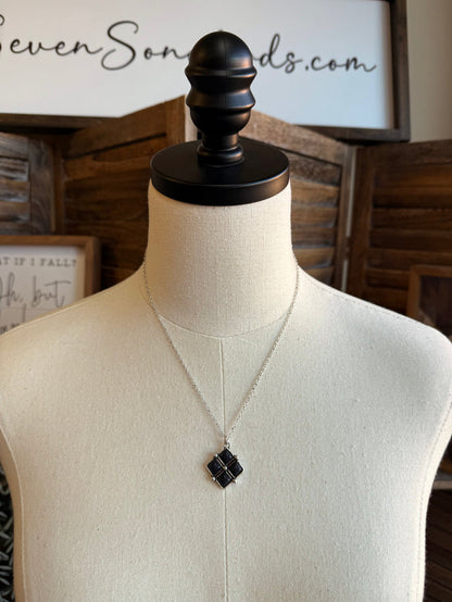 Diamond four-stone necklace with a black square pendant on a silver chain