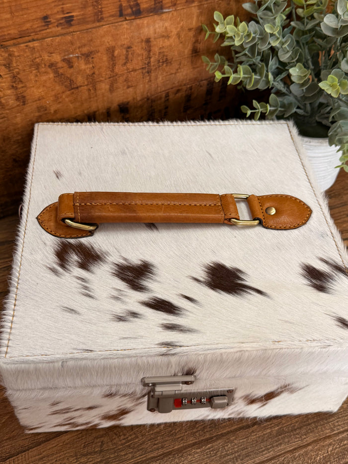 Hair-on cowhide jewelry box with tan leather strap on lid and front lock