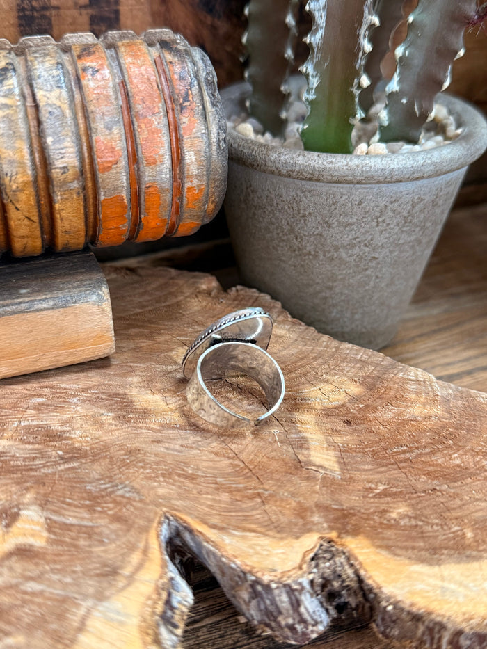 Adjustable silver-tone ring side view, oval iridescent stone cabochon on open band