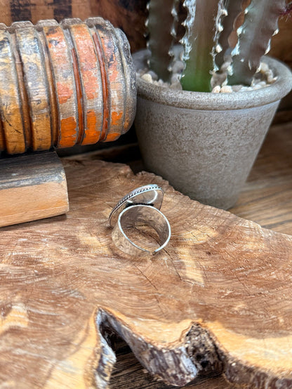 Adjustable silver-tone ring side view, oval iridescent stone cabochon on open band