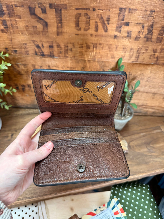 Brown leather bifold wallet open view with card slots and snap button interior