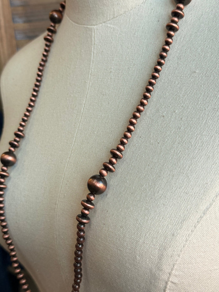 Close-up of mixed copper pearl beads on a long strand necklace