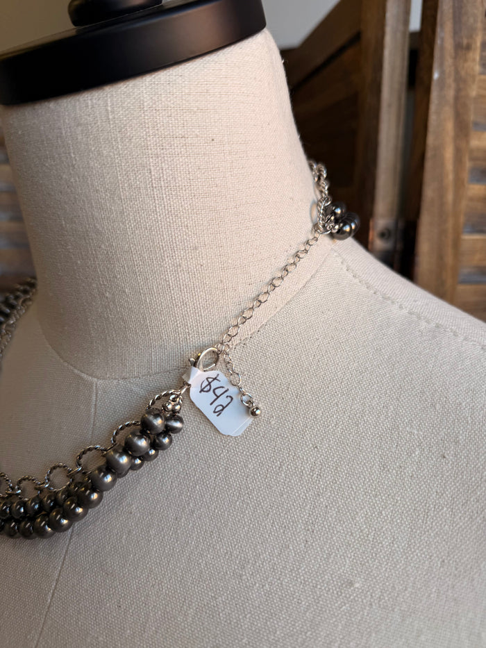 Triple-layer bead and chain necklace with small charm pendant and dark beads