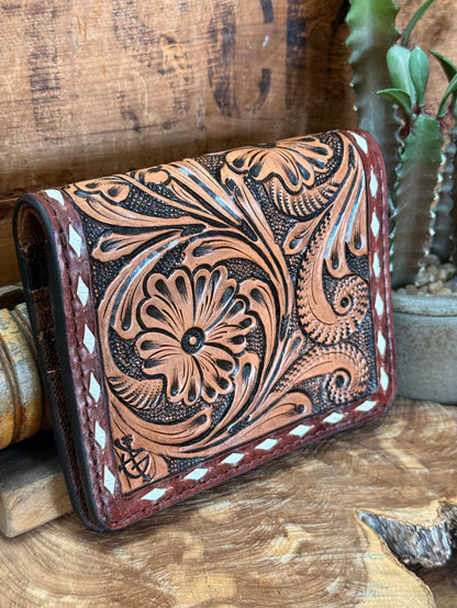 Tooled cowhide bifold wallet, close view of engraved floral design and stitched trim