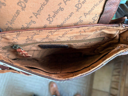 Crossbody purse interior with tan logo lining and zipper closure