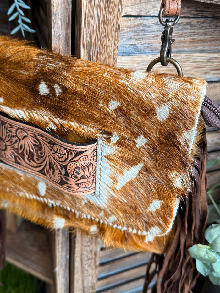 Cowhide crossbody clutch front flap with engraved concho detail and white spots