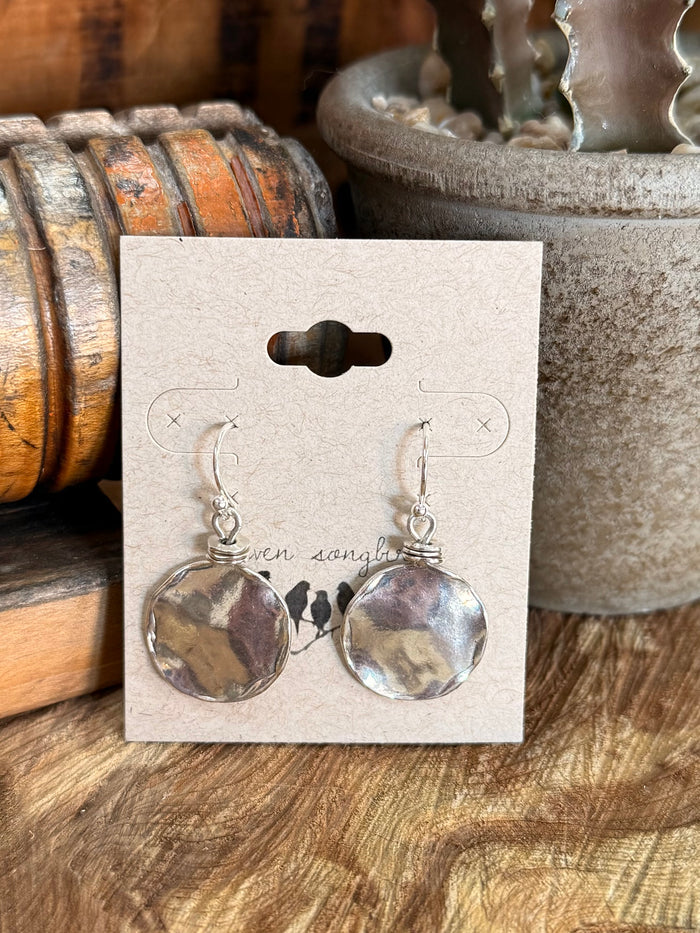 Sterling silver fishhook earrings with round hammered discs, shown on backing card