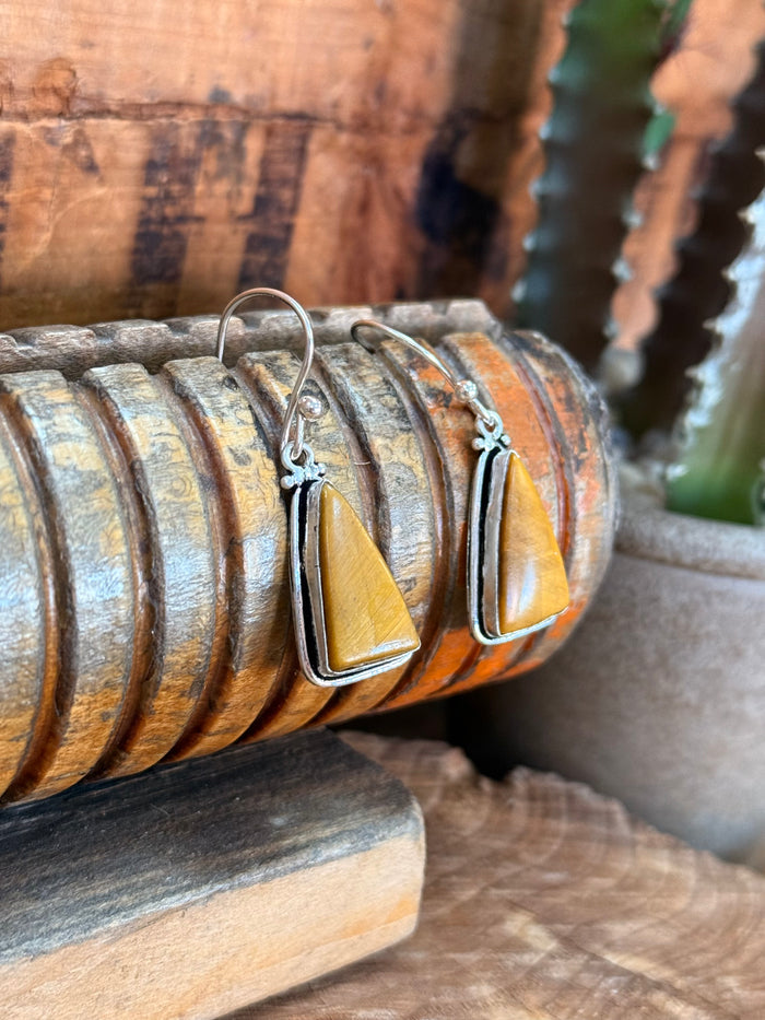 Silver fishhook earrings featuring teardrop tigereye-style yellow stone with outline frame