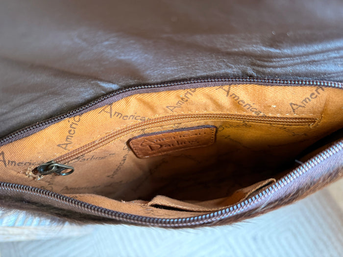 Crossbody purse interior with fabric lining and zippered top opening