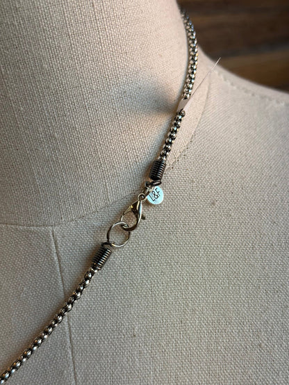 Silver chain necklace with small beads and blue crystal cross charm detail