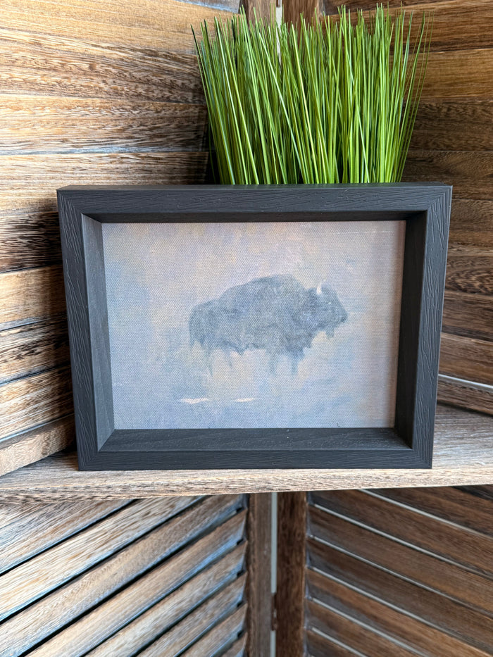 Framed buffalo artwork with dust storm print, dark gray frame and green grass accent