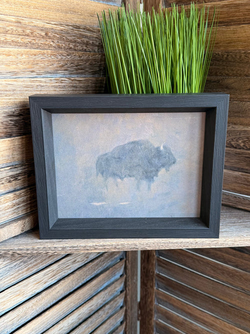 Framed buffalo artwork with dust storm print, dark gray frame and green grass accent