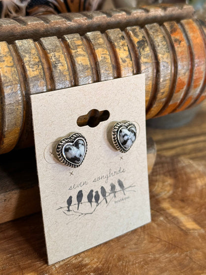 Pair of silver heart earrings with black-and-white center, shown at an angle on card