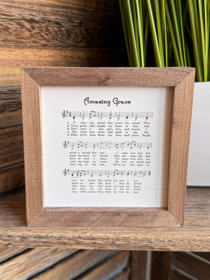 Framed sheet music artwork showing musical notes and lyrics in wood border