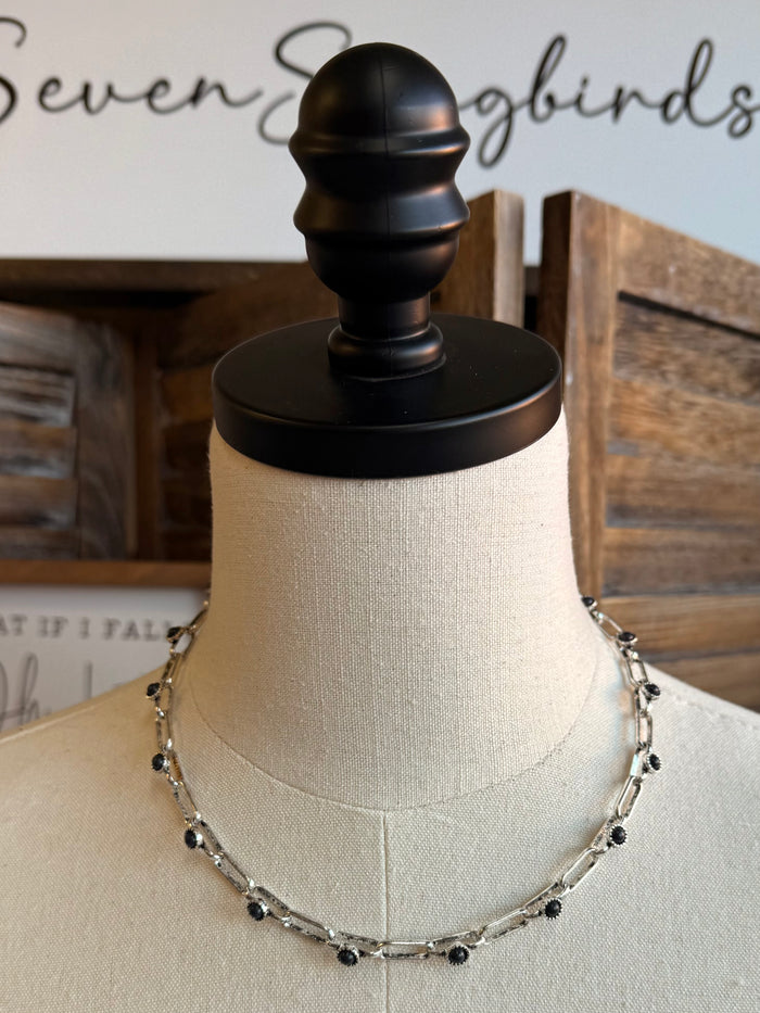 Chunky silver chain necklace with black stone accents, shown on mannequin
